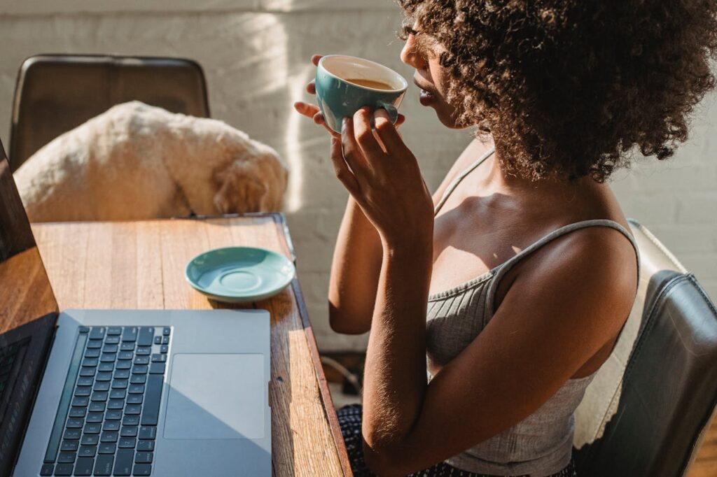 African American female freelancer using netbook near dog